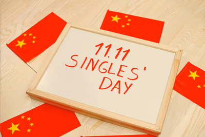 Ein Papier mit der Aufschrift 11.11. Singles Day in einem Holzrahmen.