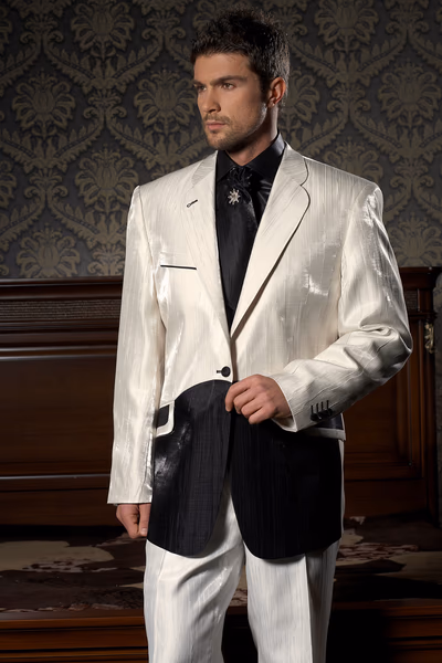 Ein stilvoll gekleideter Mann im weißen Anzug vor elegantem Hintergrund.