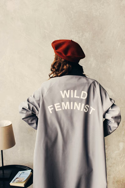 Eine Frau von hinten mit einem Mantel mit der Aufschrift Wild Feminist.