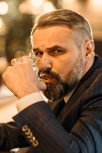 Ein Mann hält einen Drink in der Hand.