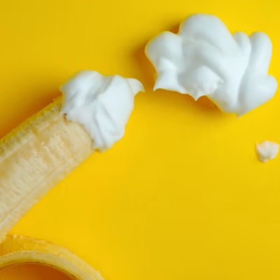 Eine Banane und Sahne als symbolisches Stillleben.